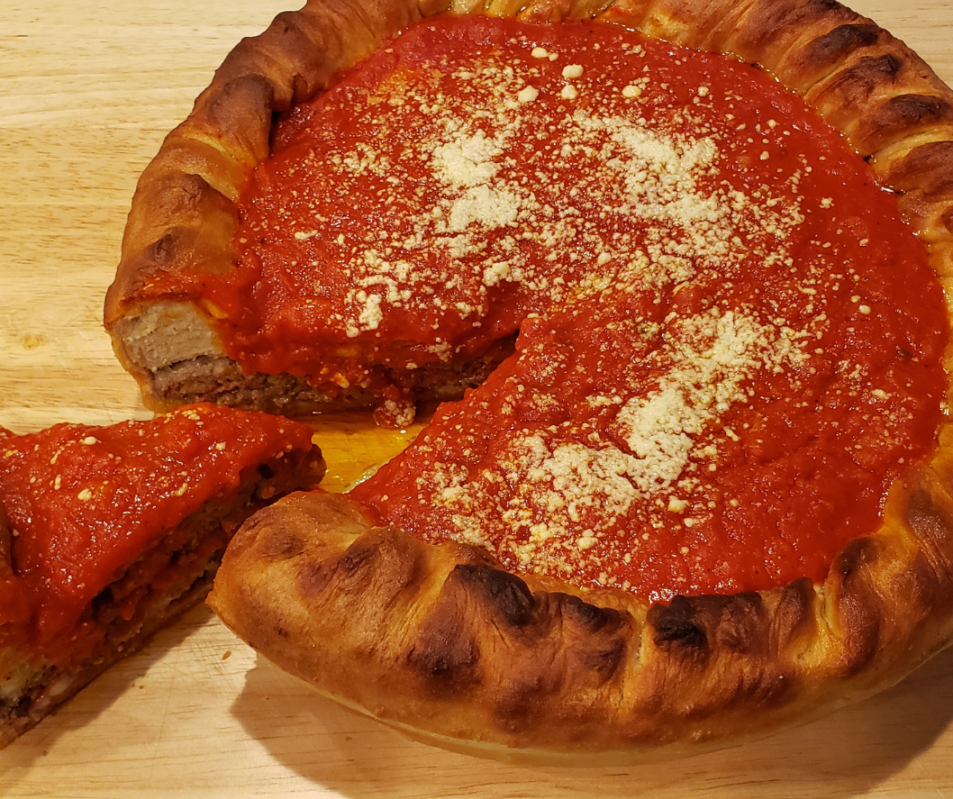 Stuffed pizza with slice cut out