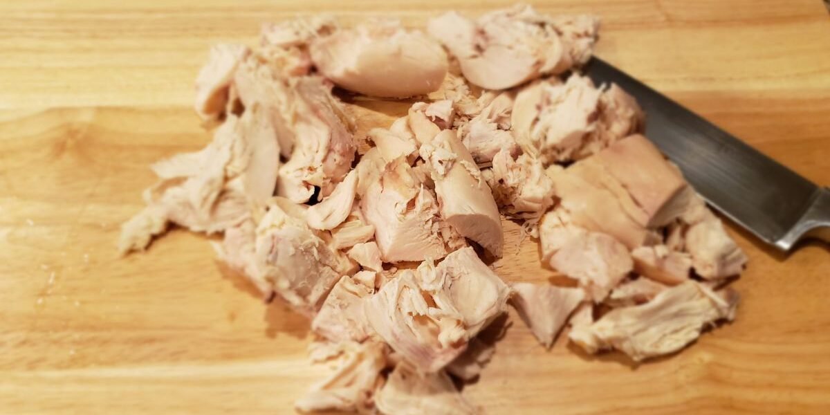 rotisserie chicken breast cut on a cutting board