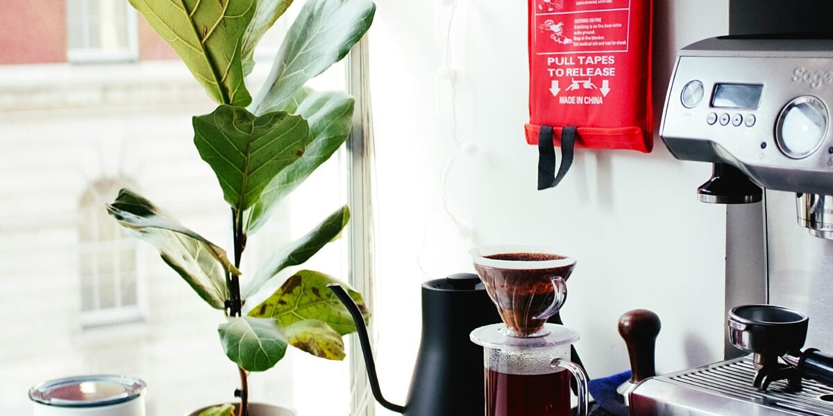 red and silver coffee maker beside white ceramic mug