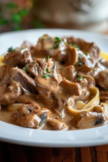 Delicious beef stroganoff served over pasta with creamy sauce and herbs.