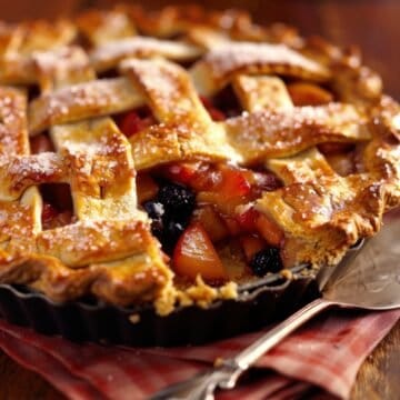 Freshly baked apple berry pie with lattice crust and powdered sugar.
